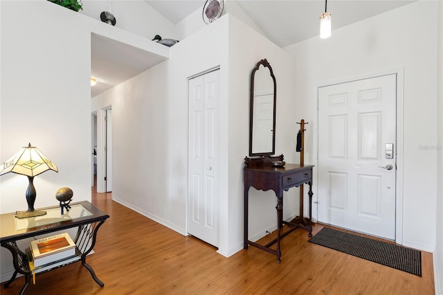 foyer featuring baseboards and wood finished floors