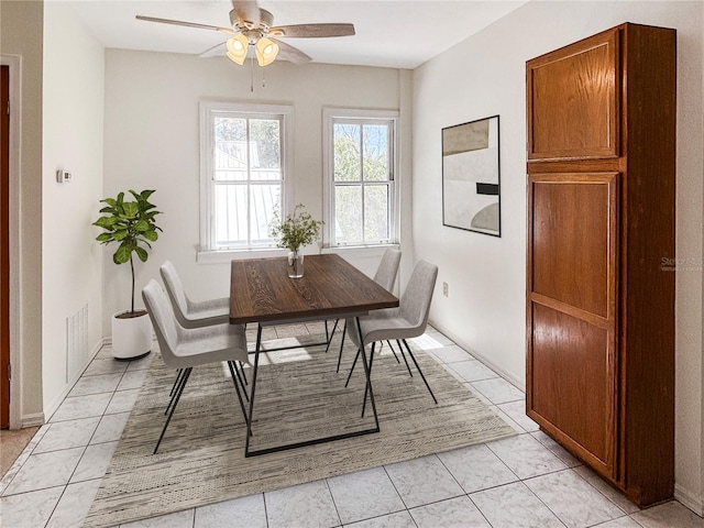 dining area with a ceiling fan, visible vents, and light tile patterned floors