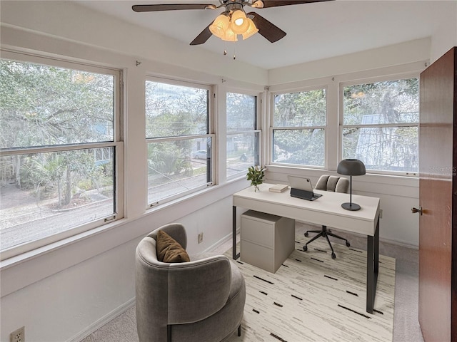 office area with a ceiling fan and baseboards
