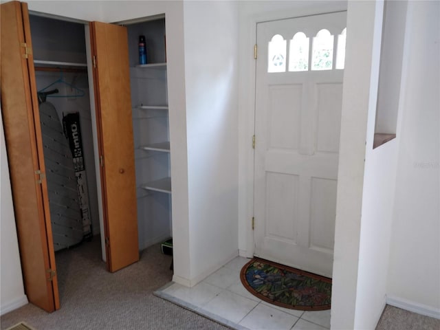 foyer entrance featuring carpet flooring and baseboards