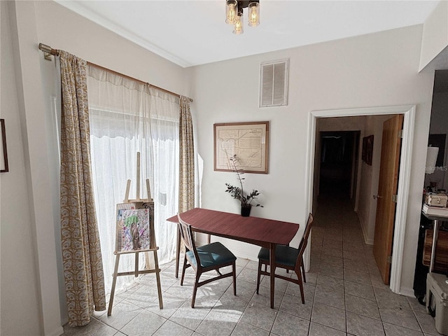dining area featuring a notable chandelier, light tile patterned flooring, and visible vents