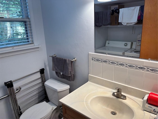 bathroom featuring vanity, a textured wall, washer / clothes dryer, and toilet
