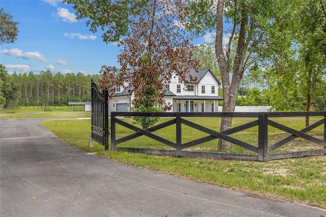 view of gate with a fenced front yard and a lawn