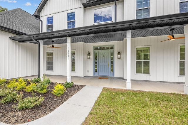 view of exterior entry with covered porch, board and batten siding, and a ceiling fan