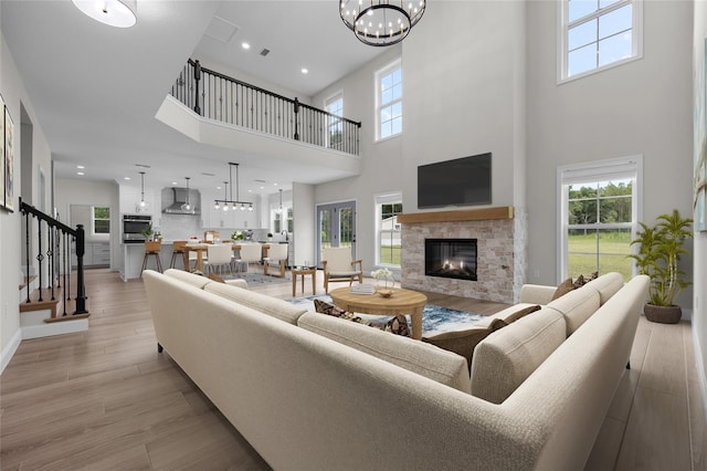 living area with a stone fireplace, plenty of natural light, and light wood-style flooring