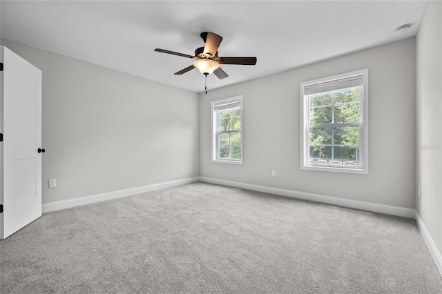 unfurnished room featuring a ceiling fan, carpet flooring, and baseboards