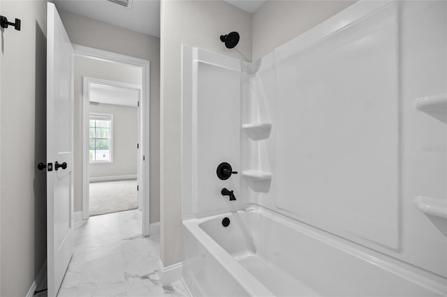 full bath featuring marble finish floor, tub / shower combination, and baseboards