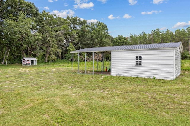 view of yard with a carport and an outdoor structure