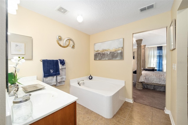 ensuite bathroom featuring a textured ceiling, ensuite bath, visible vents, and a bath