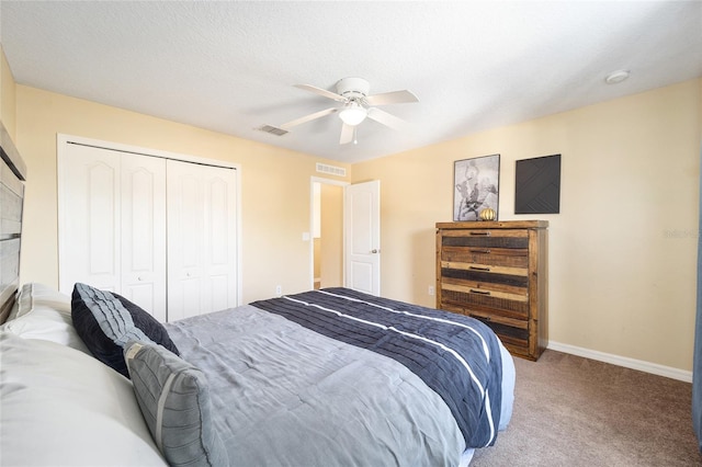 carpeted bedroom featuring a ceiling fan, a closet, visible vents, and baseboards