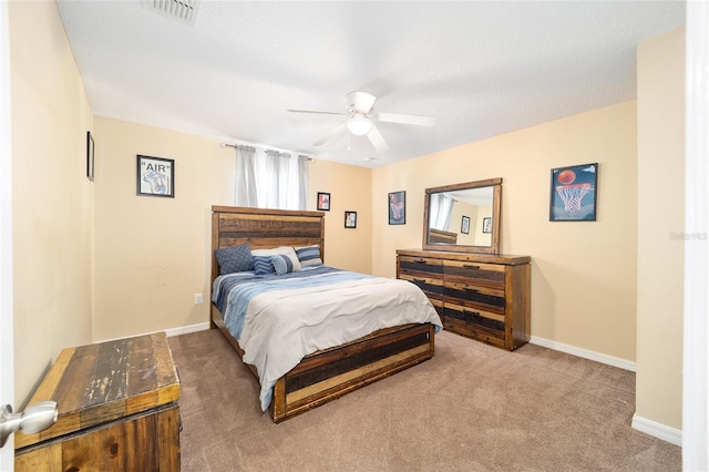 carpeted bedroom featuring baseboards, visible vents, and a ceiling fan