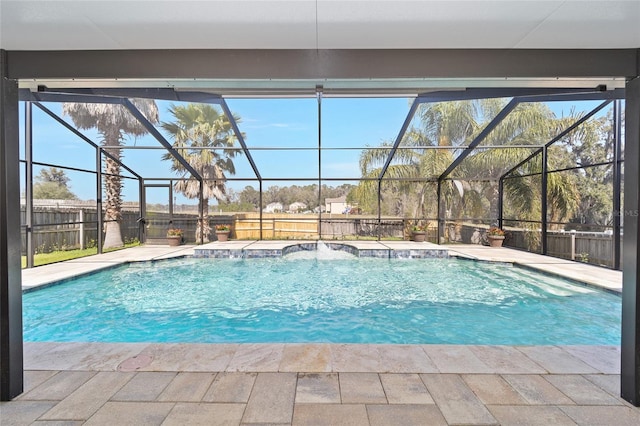 view of swimming pool featuring glass enclosure, a patio, a fenced backyard, and a fenced in pool