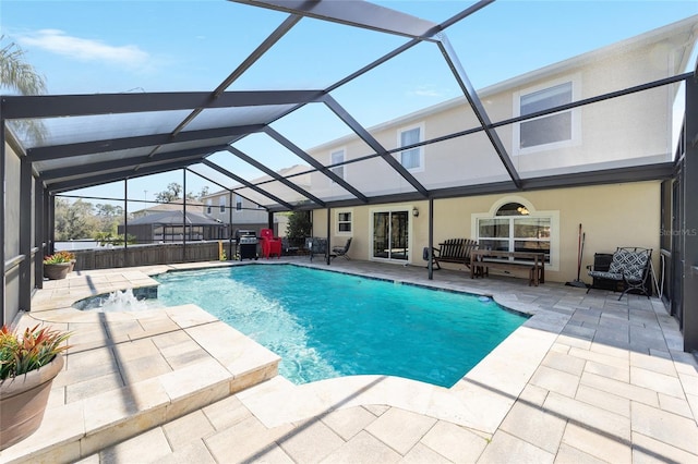 view of swimming pool with a fenced in pool, glass enclosure, and a patio area