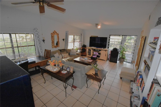 living area featuring ceiling fan, vaulted ceiling, and light tile patterned floors