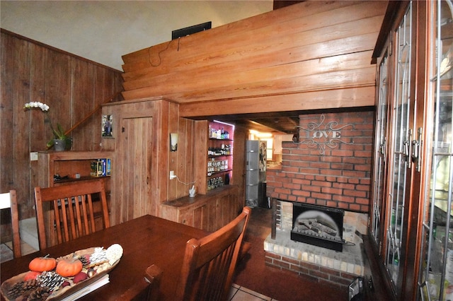 dining area featuring a fireplace and wood walls