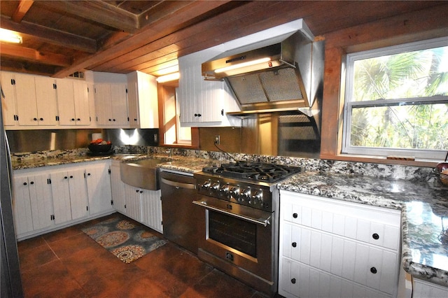 kitchen with premium range hood, white cabinetry, stainless steel appliances, and a sink