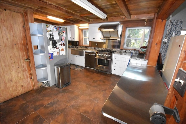 kitchen featuring wall chimney range hood, high end stainless steel range, fridge, dishwasher, and beamed ceiling