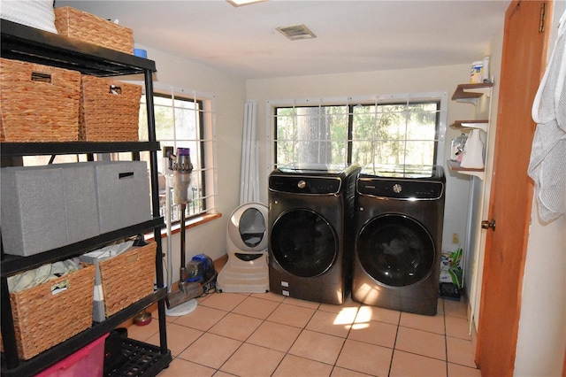 washroom featuring laundry area, tile patterned flooring, washing machine and clothes dryer, and visible vents