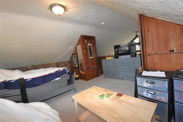 bedroom with vaulted ceiling, a textured ceiling, and carpet