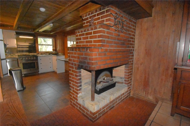 interior space featuring a fireplace, wooden walls, oven, high end range, and tile patterned floors