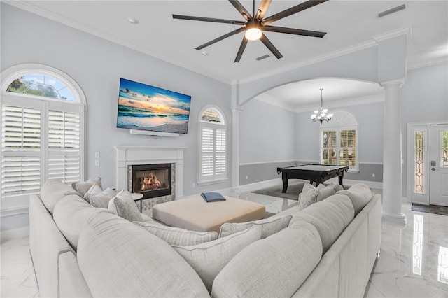 living area featuring marble finish floor, plenty of natural light, visible vents, and ornate columns