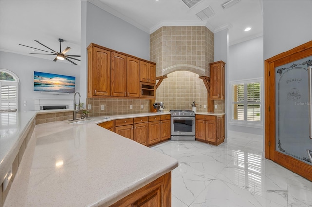 kitchen featuring a sink, marble finish floor, ornamental molding, stainless steel gas range, and tasteful backsplash