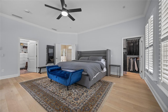 bedroom with baseboards, visible vents, crown molding, and light wood finished floors