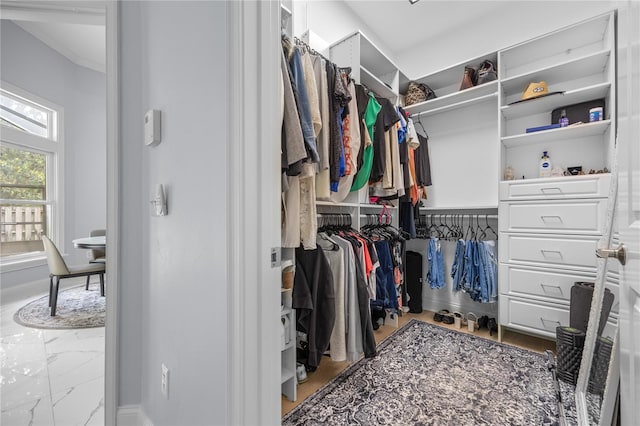 walk in closet featuring marble finish floor