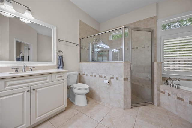 bathroom with toilet, vanity, a shower stall, a bath, and tile patterned floors