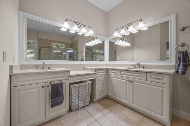 bathroom with double vanity, a stall shower, a sink, and tile patterned floors