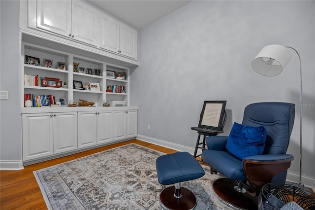 living area with light wood-type flooring and baseboards