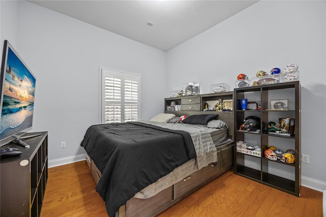 bedroom with wood finished floors and baseboards