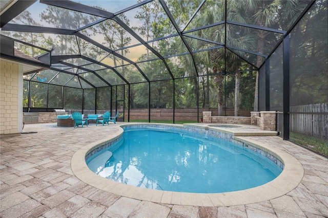 pool with glass enclosure, a patio, fence, and an in ground hot tub