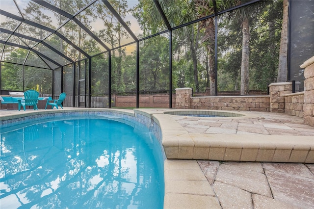 outdoor pool featuring a lanai, a patio area, and an in ground hot tub