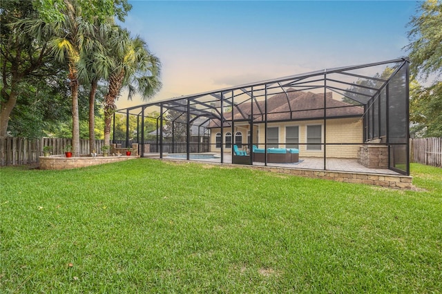 view of yard featuring a fenced in pool, glass enclosure, a fenced backyard, and a patio