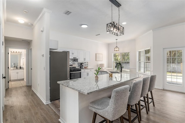 kitchen with dark wood-style floors, crown molding, stainless steel appliances, and backsplash