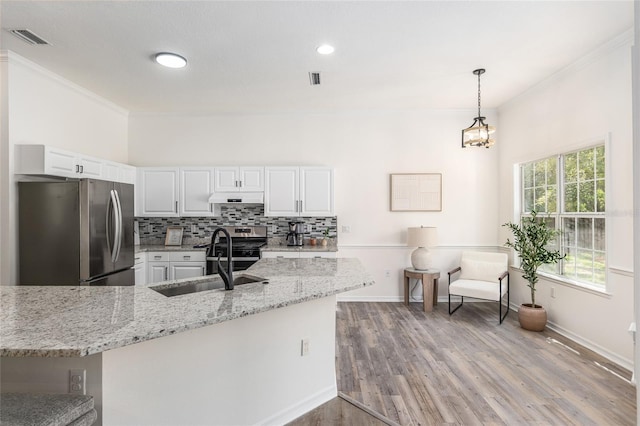 kitchen featuring visible vents, backsplash, appliances with stainless steel finishes, a sink, and under cabinet range hood