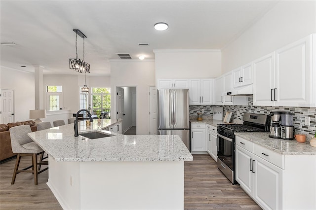 kitchen featuring appliances with stainless steel finishes, backsplash, a sink, and under cabinet range hood