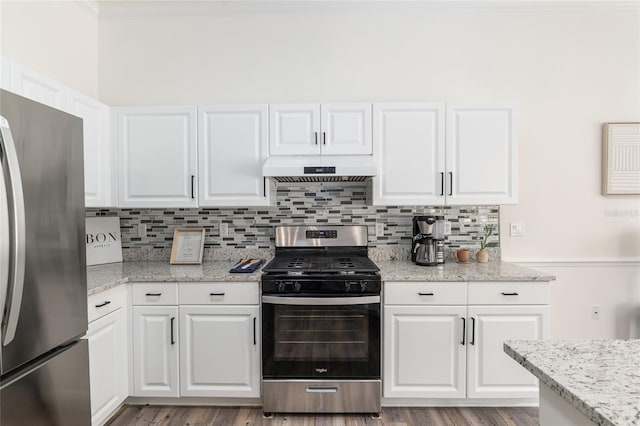 kitchen with under cabinet range hood, tasteful backsplash, appliances with stainless steel finishes, and white cabinets