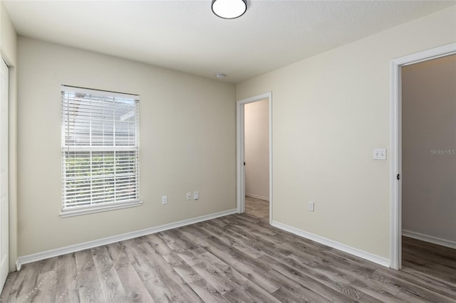 unfurnished bedroom with baseboards and wood finished floors