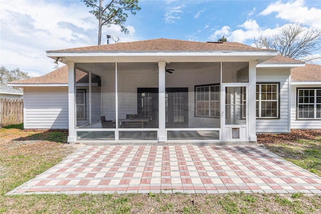 back of house with a sunroom and roof with shingles