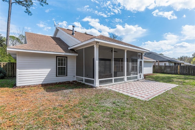 back of property with ceiling fan, fence, a sunroom, a yard, and a patio area