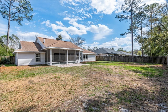 rear view of property featuring a sunroom, a fenced backyard, and a yard