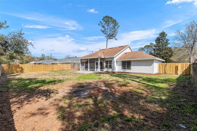 back of house with a sunroom, a fenced backyard, and a lawn