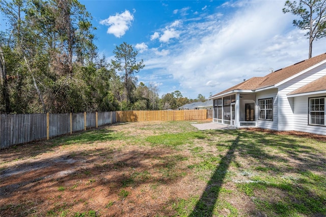 view of yard featuring a sunroom and a fenced backyard