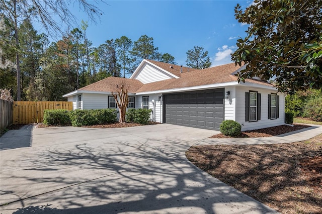 single story home with a garage, driveway, and fence