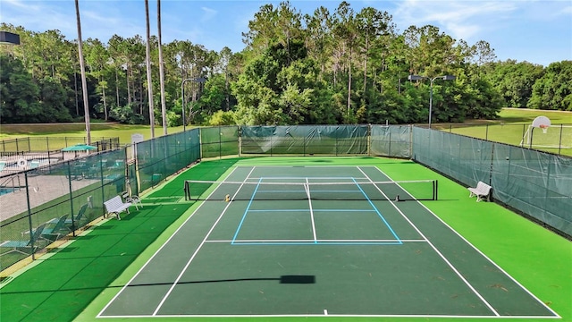 view of tennis court featuring fence