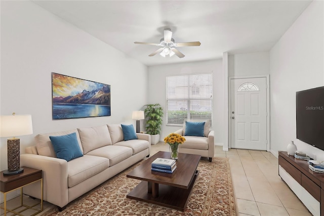 living room with light tile patterned floors, ceiling fan, and baseboards