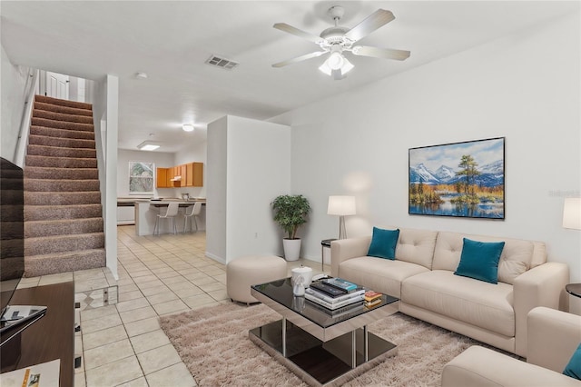 living room with stairs, light tile patterned flooring, visible vents, and a ceiling fan