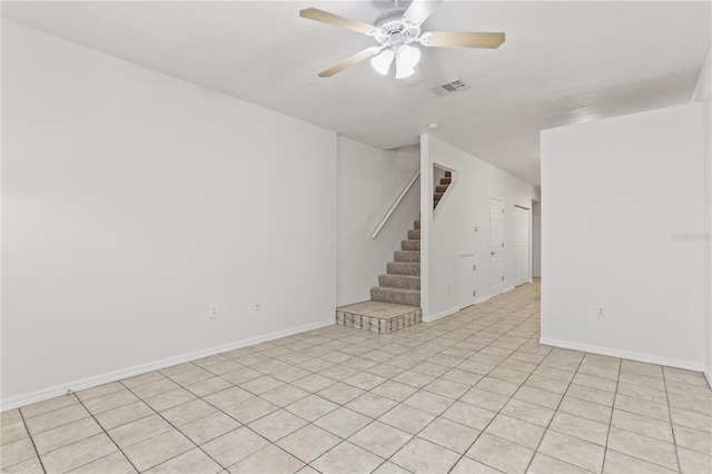 unfurnished room featuring ceiling fan, stairs, baseboards, and visible vents